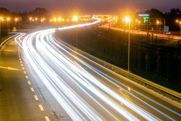 istock light trails on motorway highway at night, long exposure 1034730420