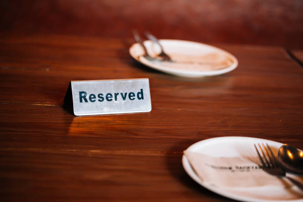 istock 'Reserved' Sign on dining table in restaurant with spoon, fork and plate. 1034742746