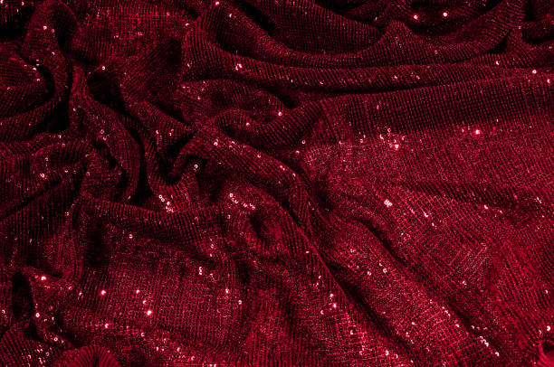istock Texture, background, pattern, red fabric with paillettes. Look at these neon red sequins. Round neon pink sparkles glitter overlapping iridescent glitter on a clean purple grid. 1034743690