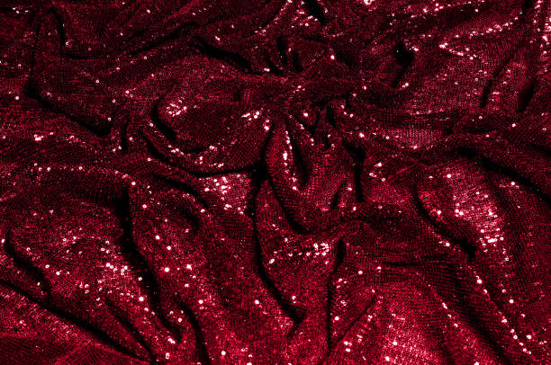 istock Texture, background, pattern, red fabric with paillettes. Look at these neon red sequins. Round neon pink sparkles glitter overlapping iridescent glitter on a clean purple grid. 1034743750