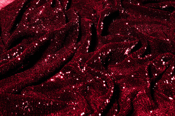 istock Texture, background, pattern, red fabric with paillettes. Look at these neon red sequins. Round neon pink sparkles glitter overlapping iridescent glitter on a clean purple grid. 1034743836