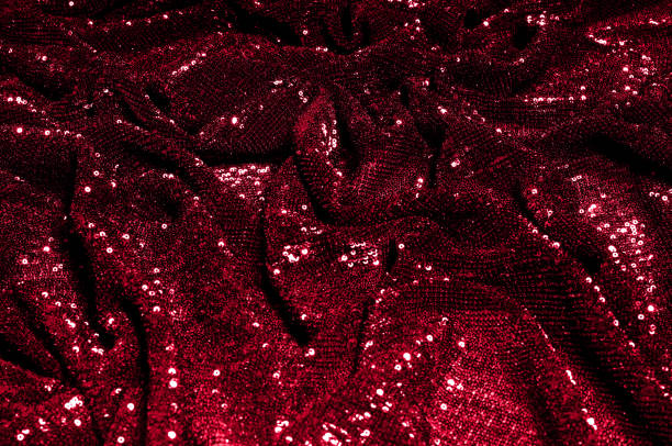 istock Texture, background, pattern, red fabric with paillettes. Look at these neon red sequins. Round neon pink sparkles glitter overlapping iridescent glitter on a clean purple grid. 1034743880