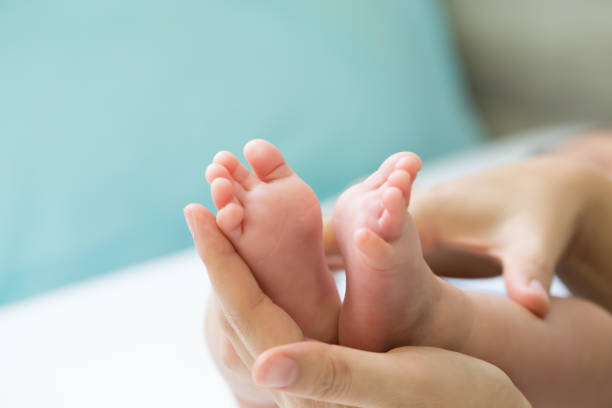 istock Foot baby on mother hand 1034746026