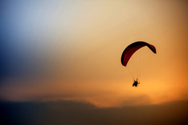 istock Guy flying on the coloful sky by paramotor kite,extreme activity port. feel freedom like birds. concept overcome the limits of human physiology. 1034746028