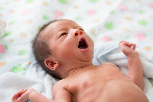 bébé asiatique bâillements après bain - baby yawning asian ethnicity newborn photos et images de collection