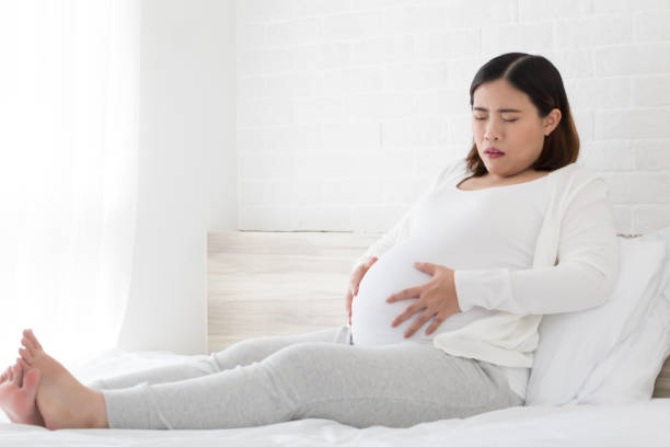 dolore addominale e crampi durante la gravidanza - cramping foto e immagini stock