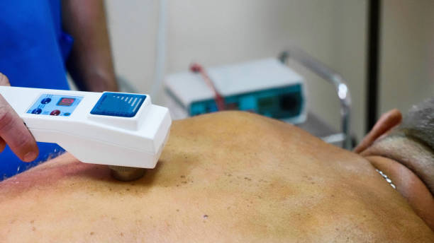 istock Senior male patient receive electrostatic therapy procedure on his back. 1034750110