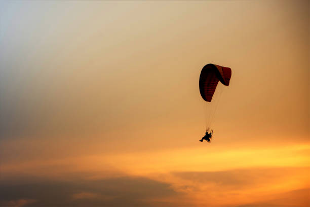 istock Guy flying on the coloful sky by paramotor kite,extreme activity port. feel freedom like birds. concept overcome the limits of human physiology. 1034753504
