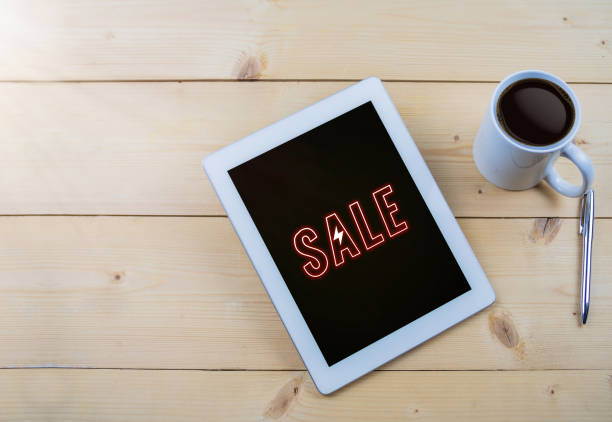 istock Sale text on tablet on wooden work table with coffee mug 1034753738