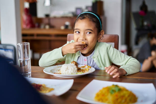 istock Girl having lunch at dining table in house 1034754030