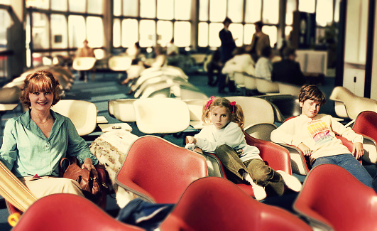 Vintage image of a mother and her children waiting at the airport.