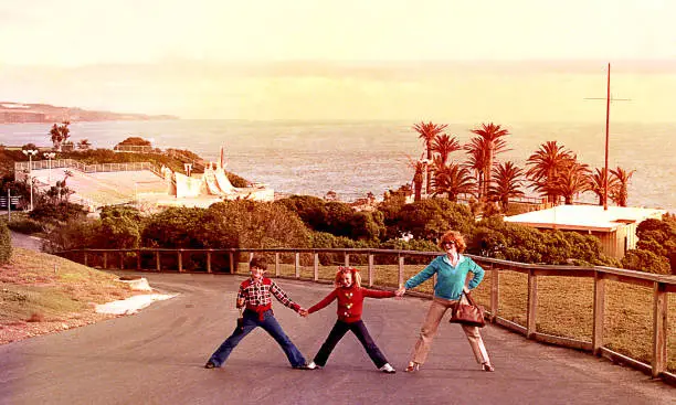 Vintage image of a mother and her children posing funny outdoors.