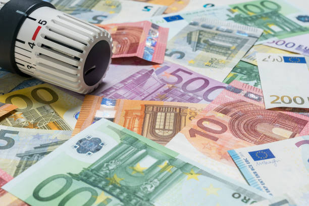 istock Heating thermostat with money, expensive heating costs concept 1034763902
