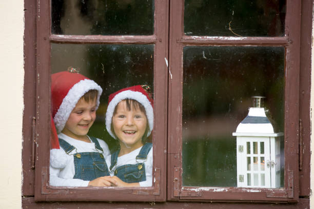 istock Two cute boys, brothers, looking through a window, waiting for Santa 1034768588