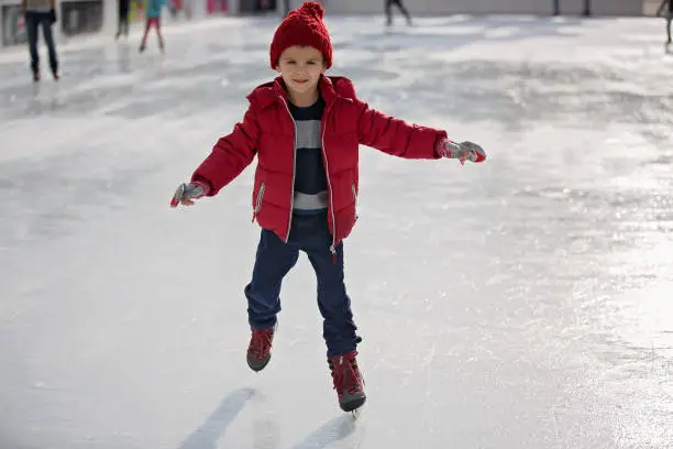 Photo of Happy boy with red hat, skating during the day, having fun