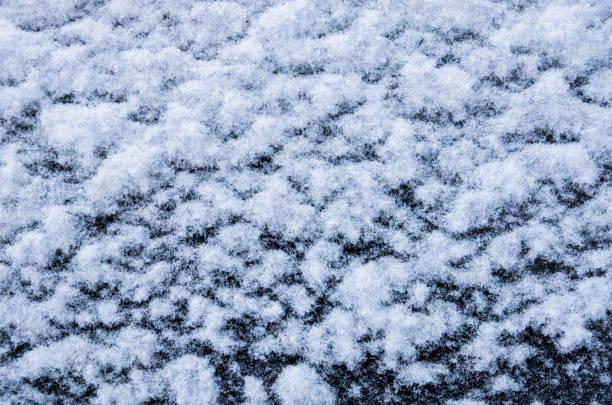 schneeweiße textur auf schwarzem hintergrund in form von flocken - snowpack stock-fotos und bilder