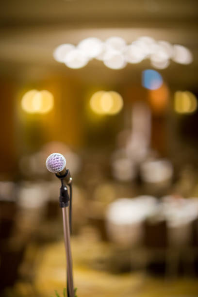 istock microphone in concert hall or conference room soft and blur style for background. 1034776248