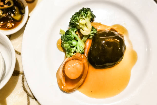 Braised abalone with mushroom and broccoli in superior sauce served in restaurant