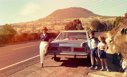 Vintage image of a mother and her children at a stop on the road.