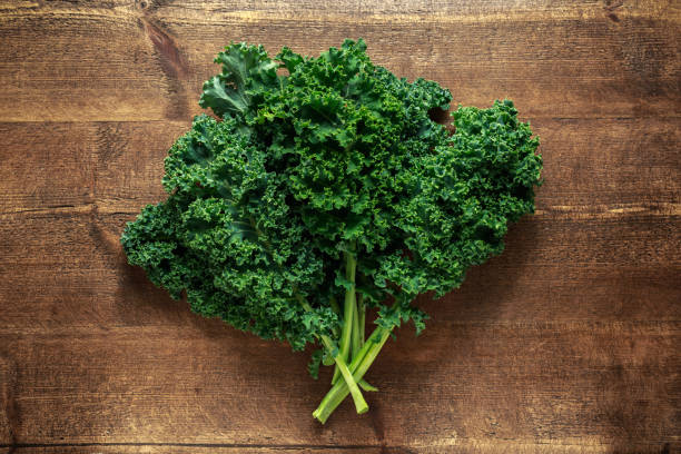 istock Raw organic freshly picked green curly kale on wooden table 1034793944
