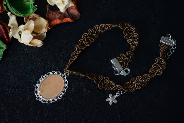 istock Brown necklace with a maple leaf pendant on a dark background close up 1034795604