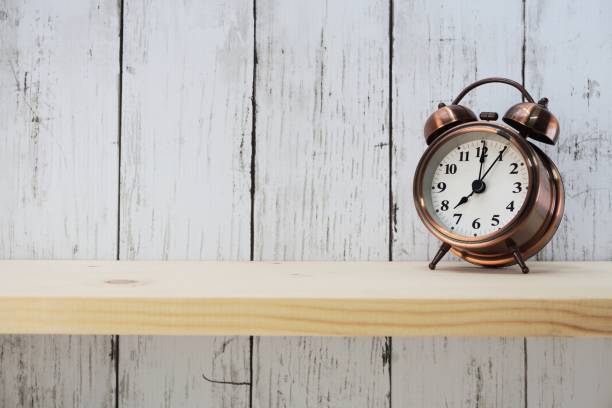 istock vintage alarm clock with space for copy on wooden background 1034817902