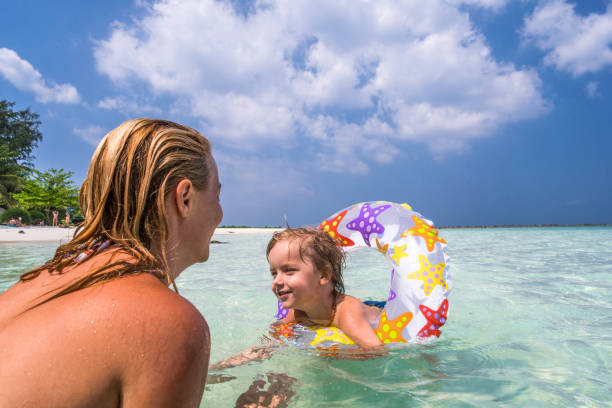 istock Mother and her small son having fun while swimming in the sea. 1034836896