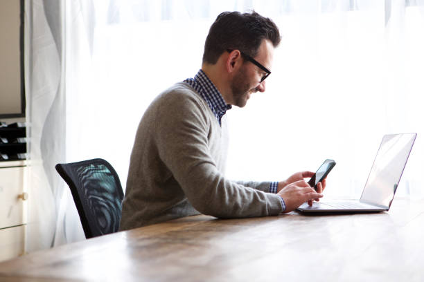 istock older man working at home with laptop and mobile phone 1034837206