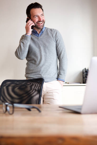istock happy man talking on mobile phone in business office 1034837230
