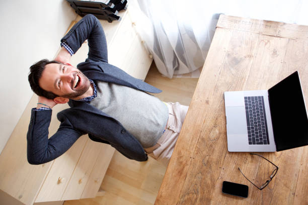 istock happy businessman relaxing in office with laptop 1034837262