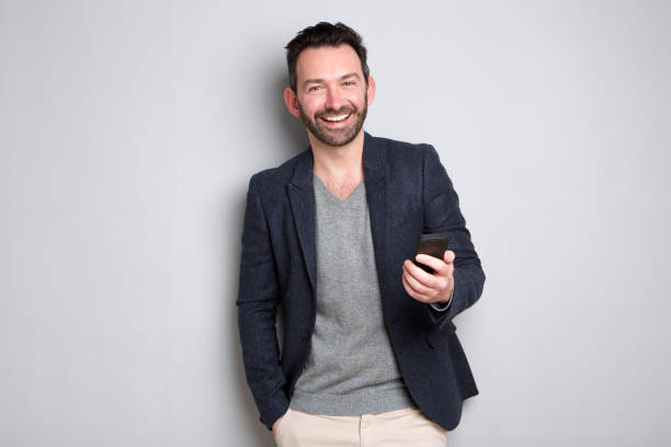 istock happy man with beard holding mobile phone 1034837294