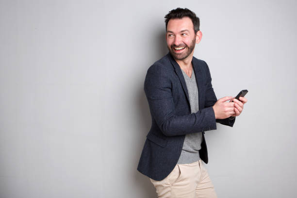 istock happy man with beard holding cell phone 1034837314