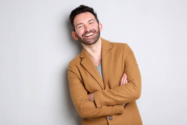 istock happy man with beard smiling against gray wall 1034837360