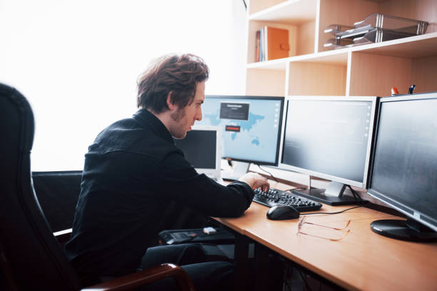istock The young dangerous hacker breaks down government services by downloading sensitive data and activating viruses. A man uses a laptop computer with many monitors 1034843006
