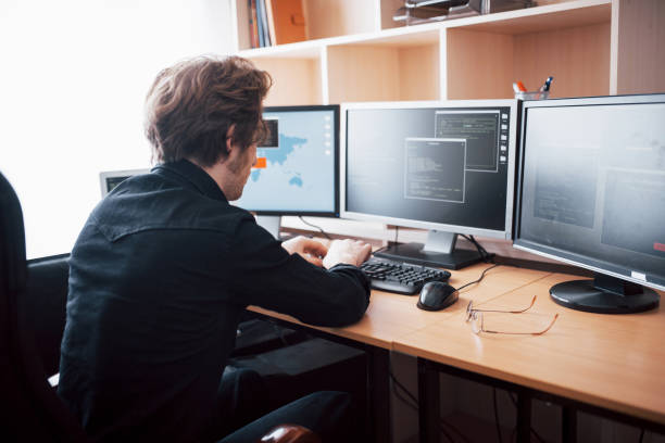 istock The young dangerous hacker breaks down government services by downloading sensitive data and activating viruses. A man uses a laptop computer with many monitors 1034843012