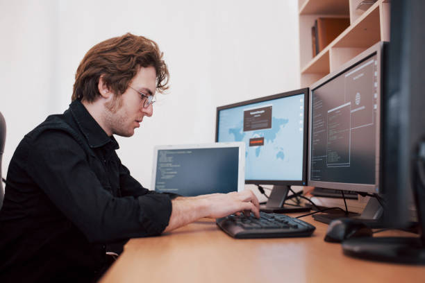 istock The young dangerous hacker breaks down government services by downloading sensitive data and activating viruses. A man uses a laptop computer with many monitors 1034843154