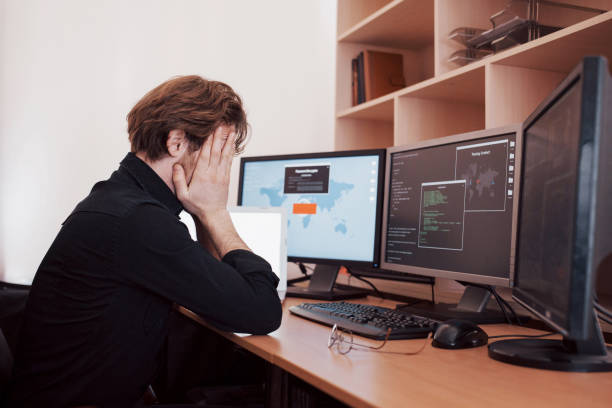 istock The young dangerous hacker breaks down government services by downloading sensitive data and activating viruses. A man uses a laptop computer with many monitors 1034843750
