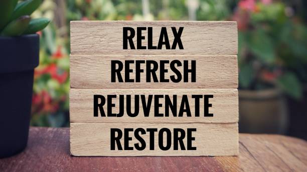 ‘Relax, refresh, rejuvenate, restore’ written on wooden blocks. Blurred vintage styled background.