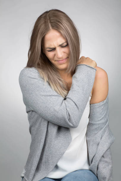 женщина имеет болезненные плечо - massaging alternative medicine headache women стоковые фото и изображения