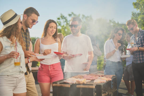 istock Group of people standing around grill. 1034850946
