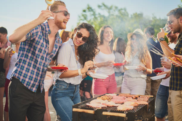 istock Group of people standing around grill. 1034851412