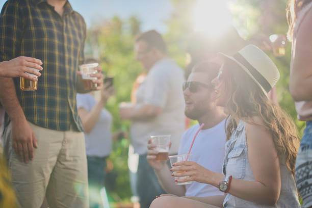 Couple sitting and drinking alcohol at outdoor party.