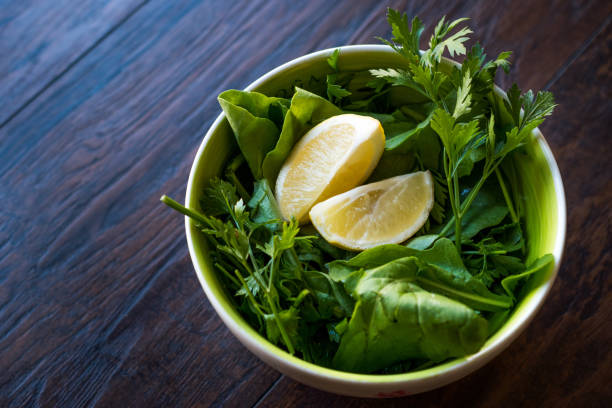 Fresh Parsley and Arugula / Rucola or Rocket Leaves with Lemon in Ceramic Bowl.