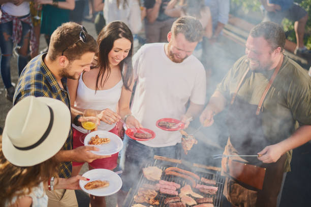 istock Group of people standing around grill. 1034854534