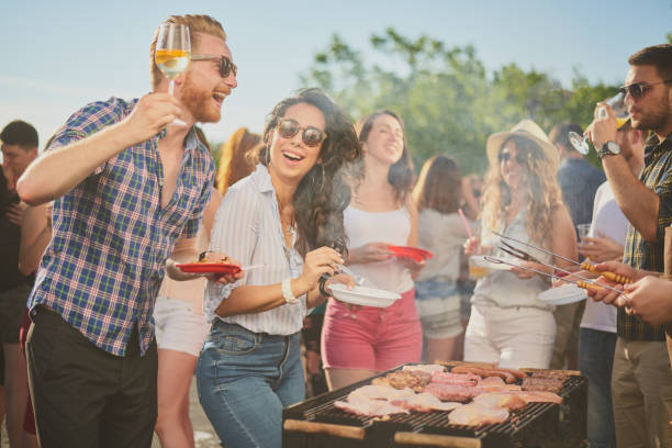 istock Group of people standing around grill. 1034854900