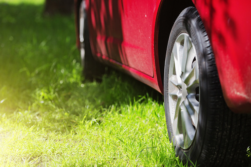 Please note: The 175/65R15 on the tire is a generic tire size spec, not a product code. 
A red car is parked on grass in dappled shade.