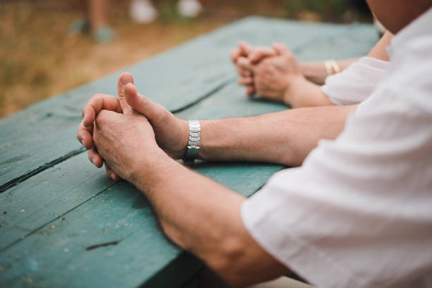 istock Hands of elderly men and women on the old rustic table 1034861244