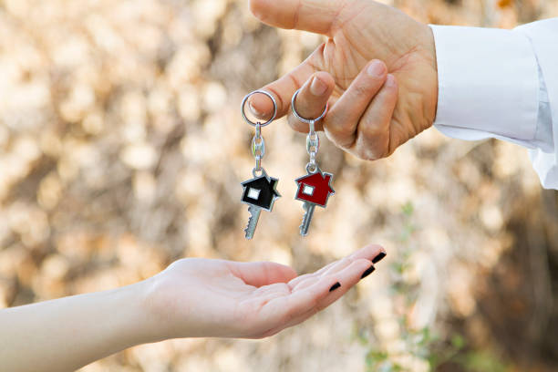 istock Human hand giving new house keys 1034862038