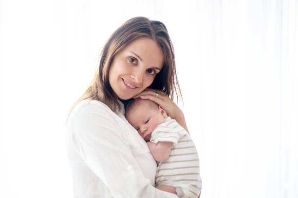 istock Young mother, holding her newborn baby boy 1034868630