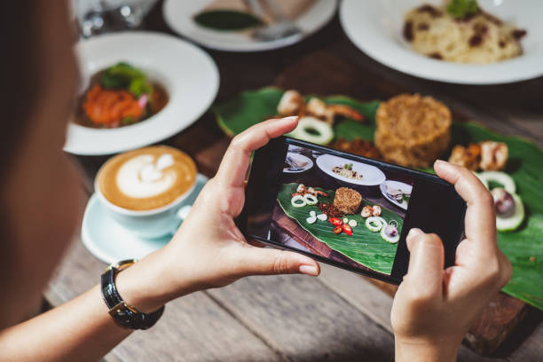 woman using phone taking photo for food dinner and lunch meal on table - food vegan food gourmet vegetarian food imagens e fotografias de stock